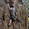 A climber further down the wall makes a high clip on an 11a
