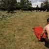 Mark cleans up the tent as cows wander through our campsite