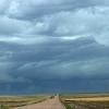 Rotating wall cloud with funnel clouds below