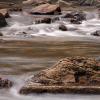 The river flows around rocks