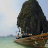 A longtail boat and a limestone island in the Andaman sea