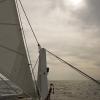 The jib sail and clouded-over sun